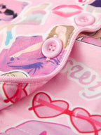 Pink kids music collage pajama top with pink button and piped front edge, closure close-up