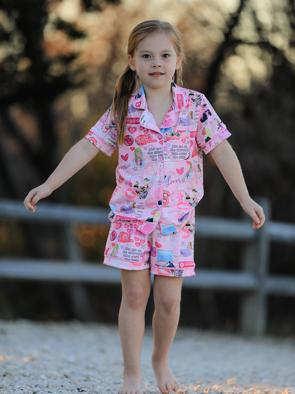 Pink kids music collage button-up pajama shorts set, modeled full front view
