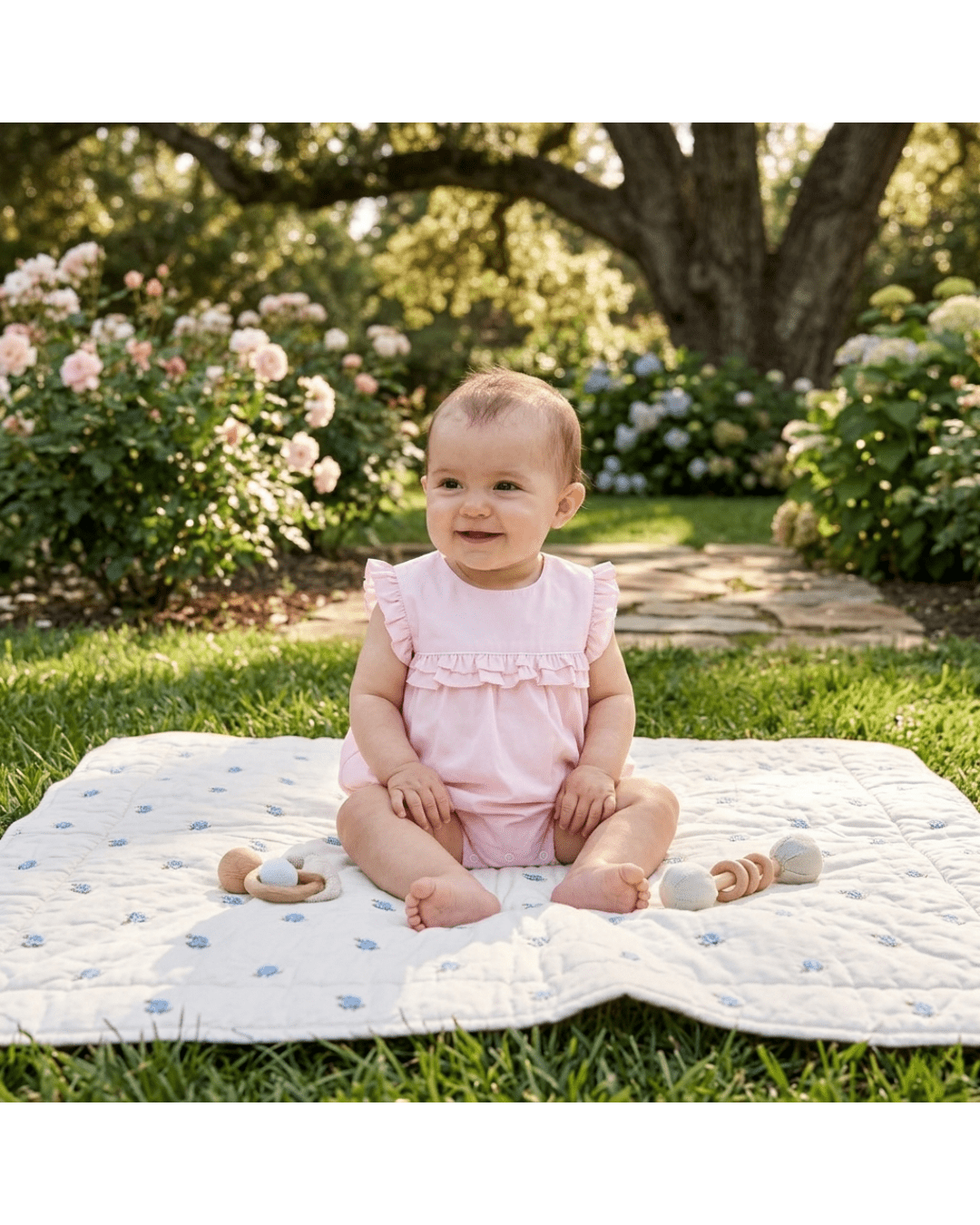 Pink baby ruffle jumper romper with layered chest ruffles, modeled outdoor front view