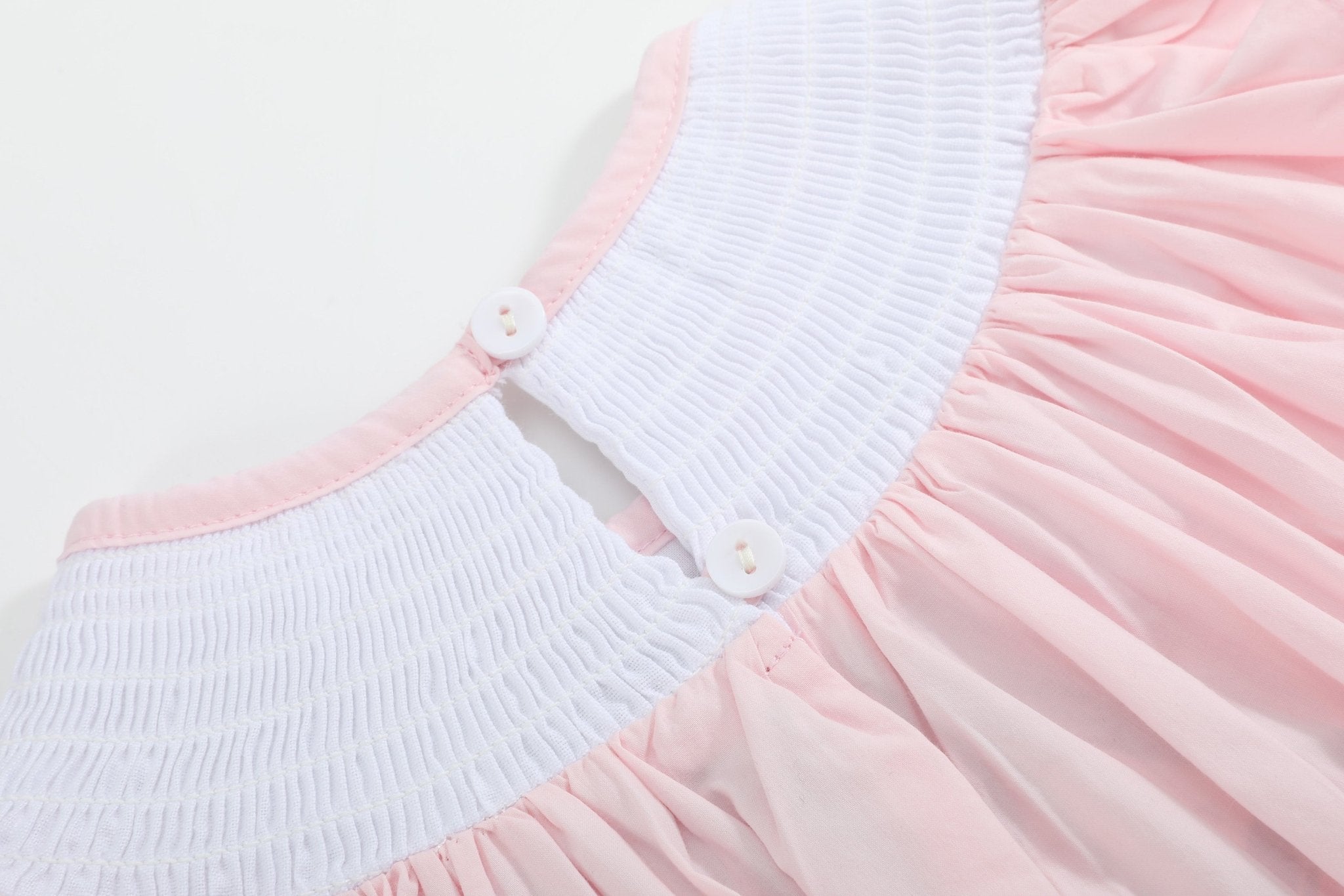 Pink kids smocked bishop dress with two-button back neckline, closure close-up
