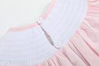 Pink baby smocked romper with two-button back neckline opening, close-up view