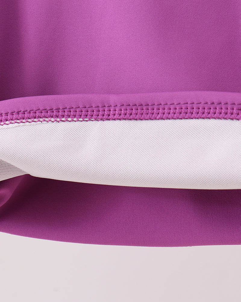 Purple performance kids activewear with reinforced seam construction, fabric detail view