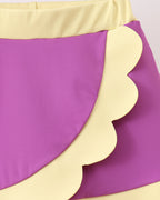 Purple kids skort with pale yellow wrap-front scalloped trim and waistband, close-up view