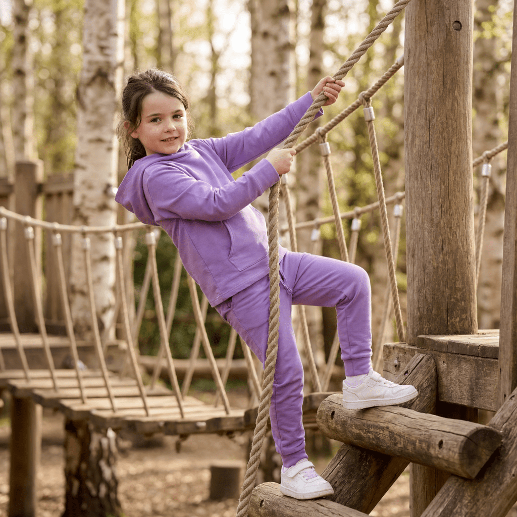 Purple kids hooded jogger set with kangaroo pocket and matching pants, playground lifestyle view