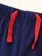 Navy kids shorts with elastic waistband and red tie detail, close-up view