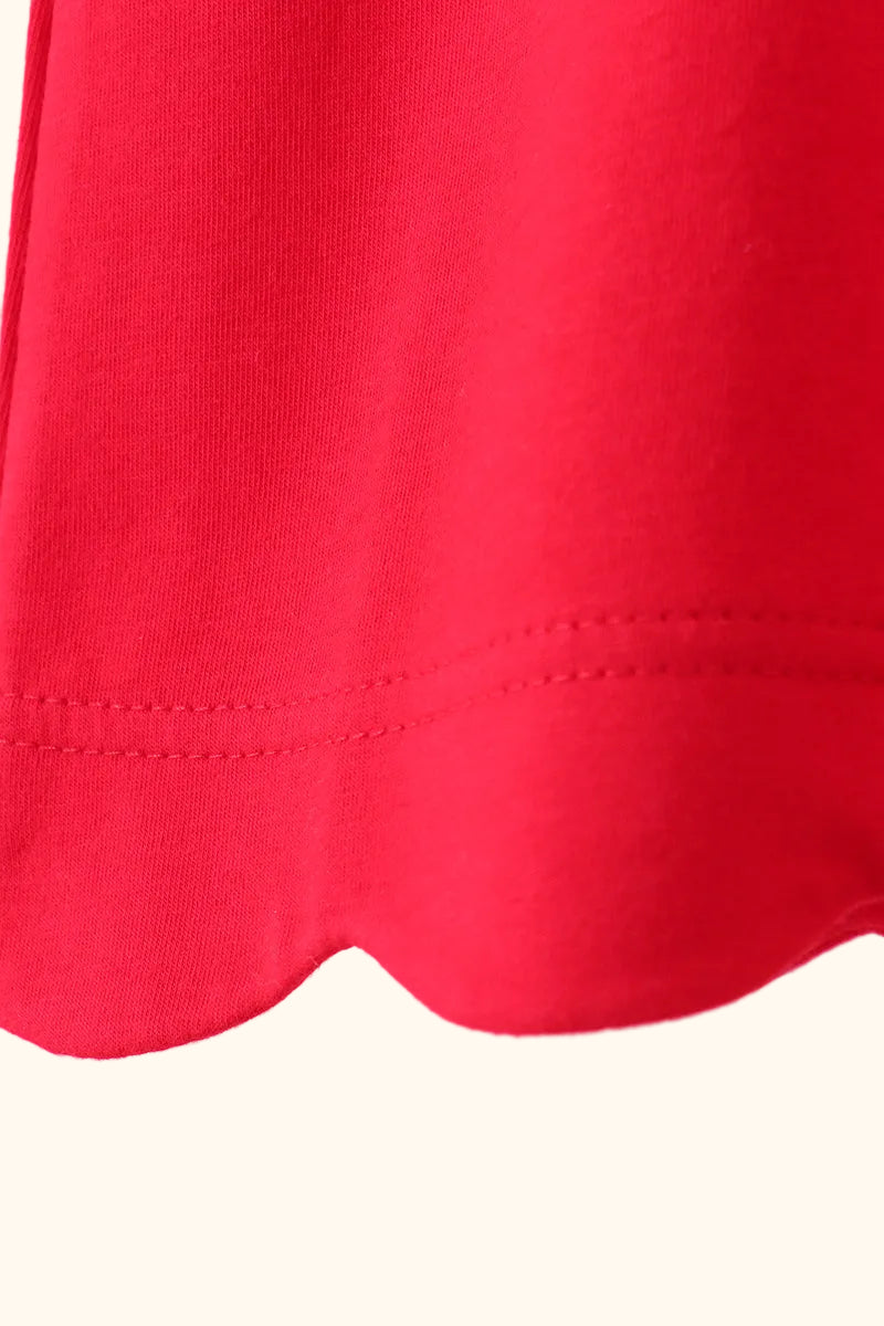 Red kids top with rounded scalloped bottom hem, close-up detail view