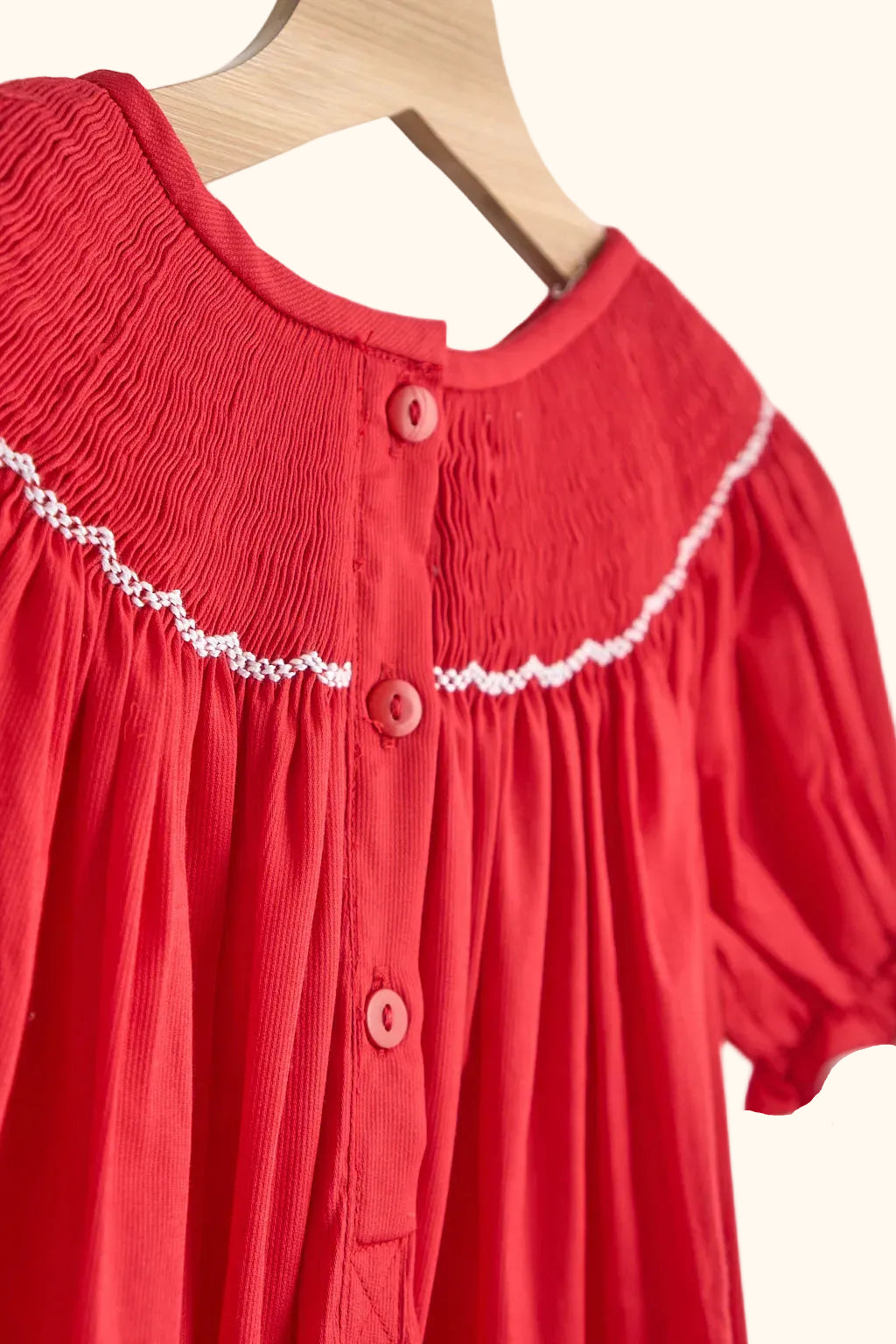 Red kids smocked dress with back button closure and white embroidery, back detail view