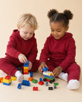 Rhubarb red kids hooded jogger set with matching pants, seated play lifestyle view