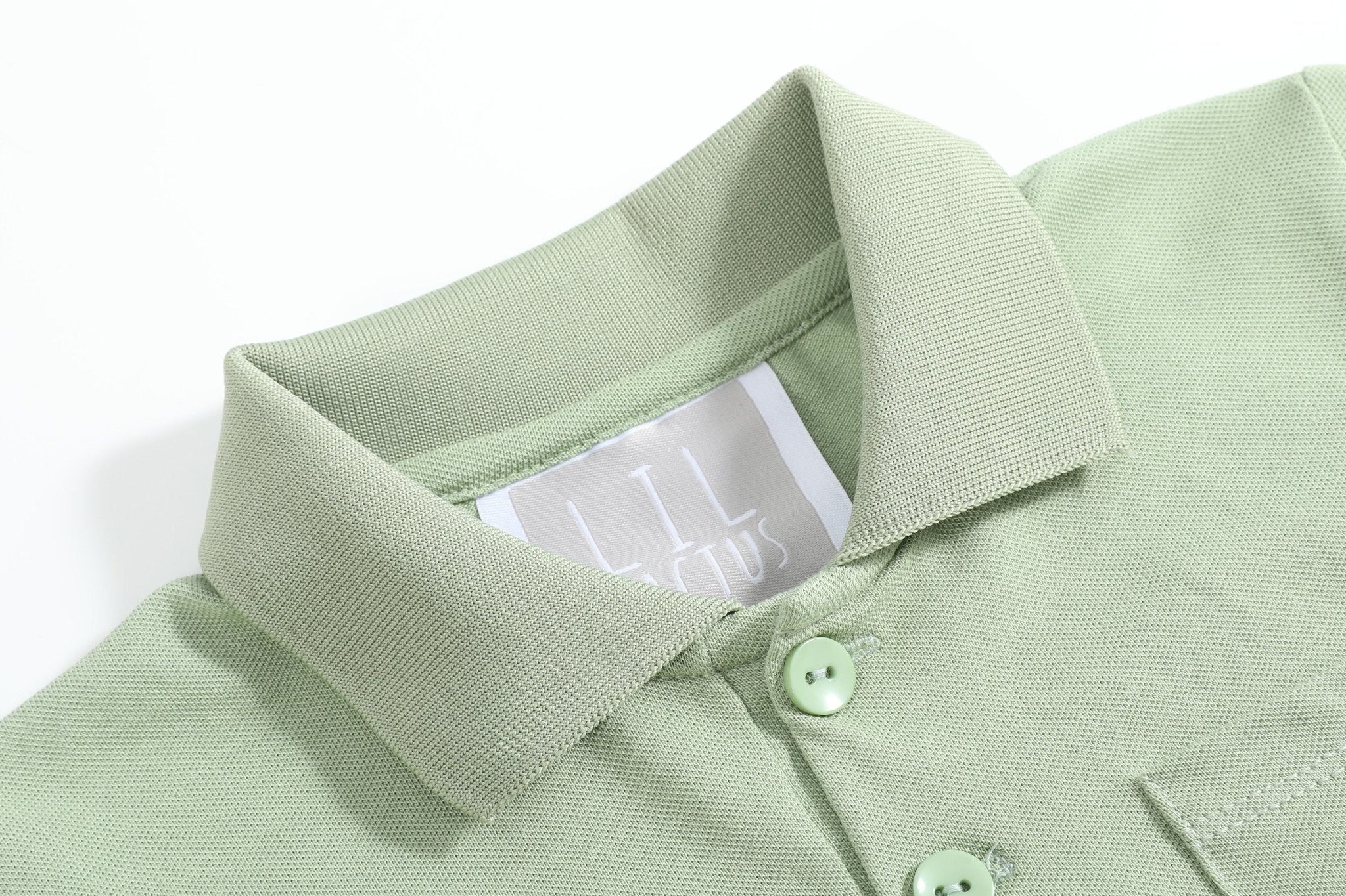 Sage green kids polo shirt with classic collar and two-button placket, neckline close-up
