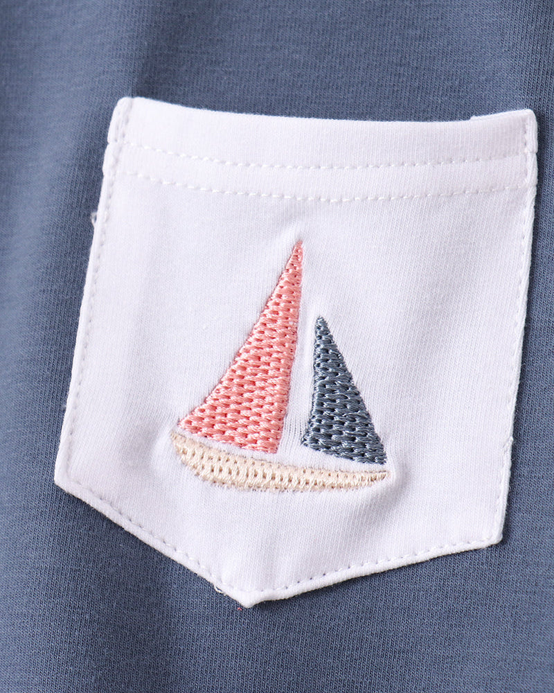 Blue kids T-shirt with white chest pocket and embroidered sailboat, close-up view