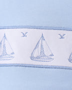 Blue kids top with three embroidered sailboats and bird details, chest close-up view
