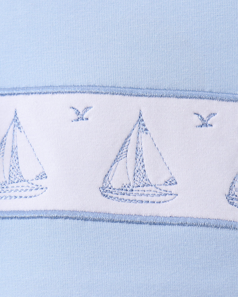 Blue kids top with three embroidered sailboats and bird details, chest close-up view