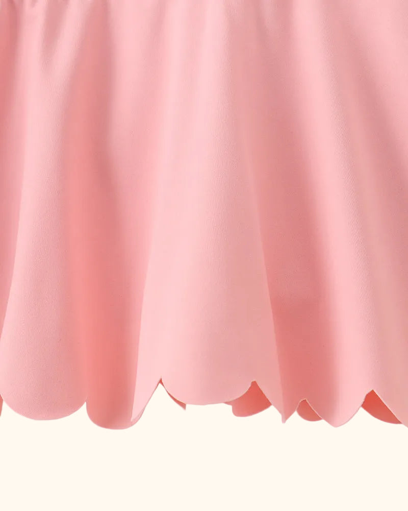 Pink kids active skort with scalloped hem, close-up detail view