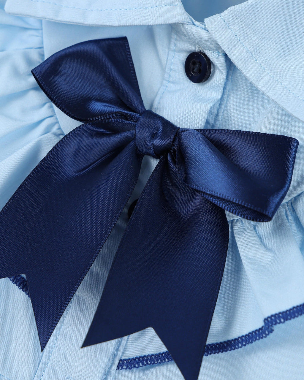 Sky blue kids cotton dress with navy satin bow and dark front button, bow detail close-up