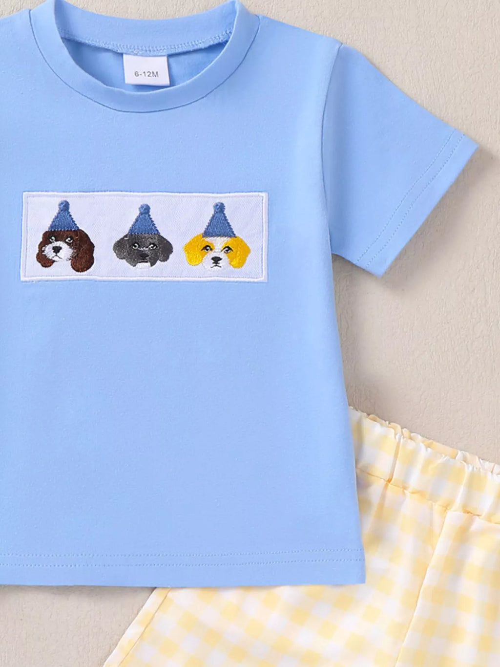 Sky blue baby short-sleeve tee with embroidered puppy patch and gingham shorts, close-up view