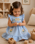 Sky blue kids floral and bunny embroidered pocket dress worn by child, front lifestyle view