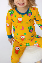 Yellow kids owl print bamboo pajamas with teal crew neckline, modeled close-up view