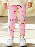 Blush pink kids unicorn print pants worn by child, front lifestyle view