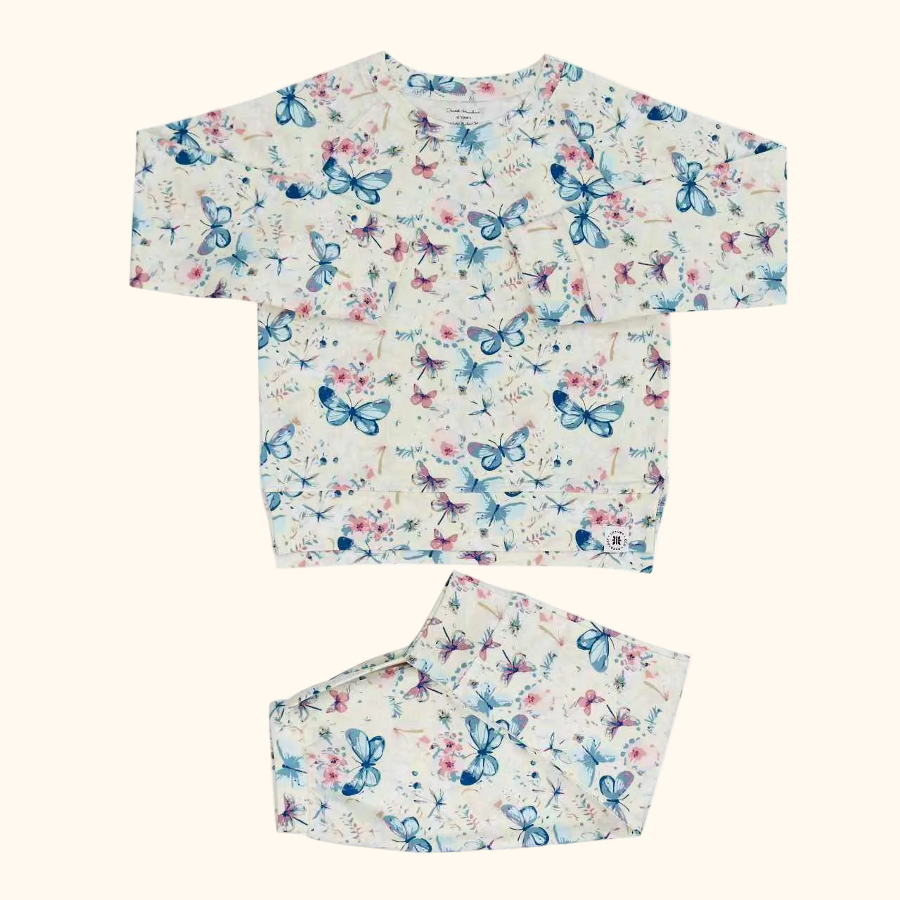 Ivory butterfly floral crew neck pocket top and matching kids jogger pants, flat lay front view