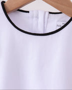 White kids top with black-trim round neckline, close-up detail view