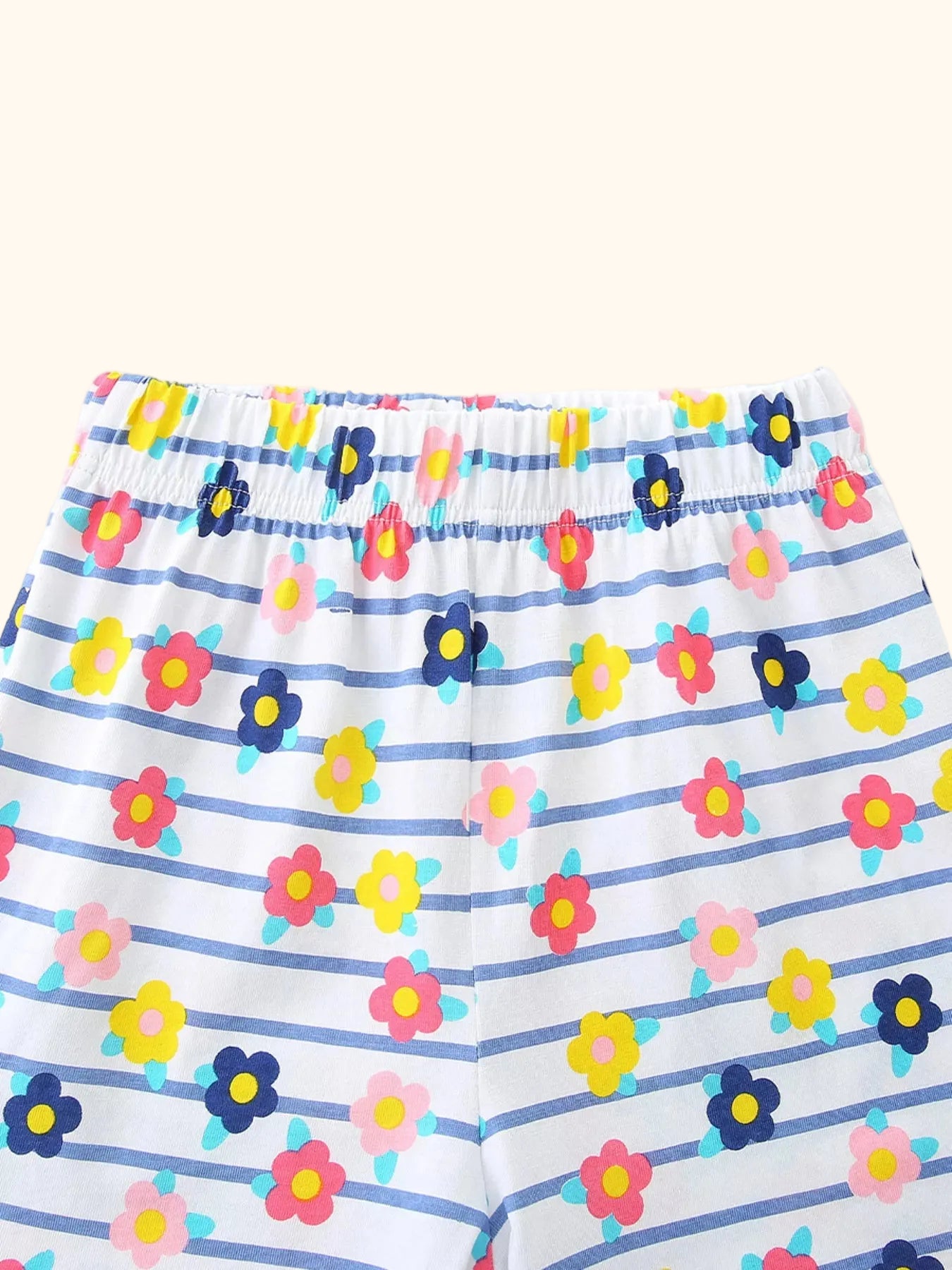White kids striped floral shorts with colorful flowers and elastic waistband, close-up view