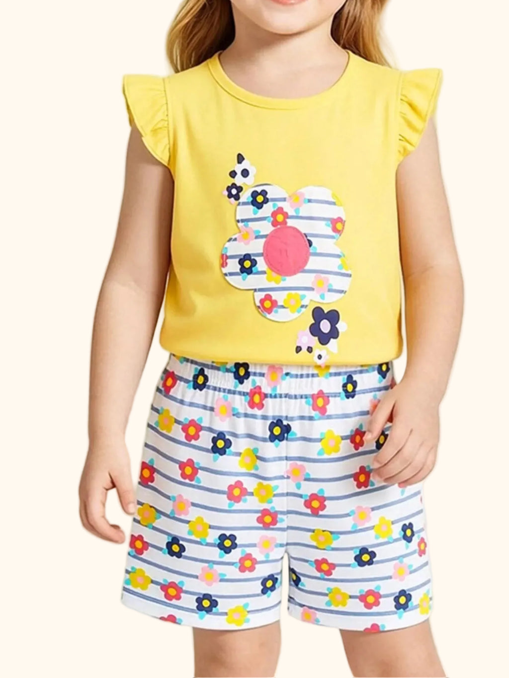 Yellow kids floral appliqué ruffle top and striped flower shorts set worn by child, front lifestyle view