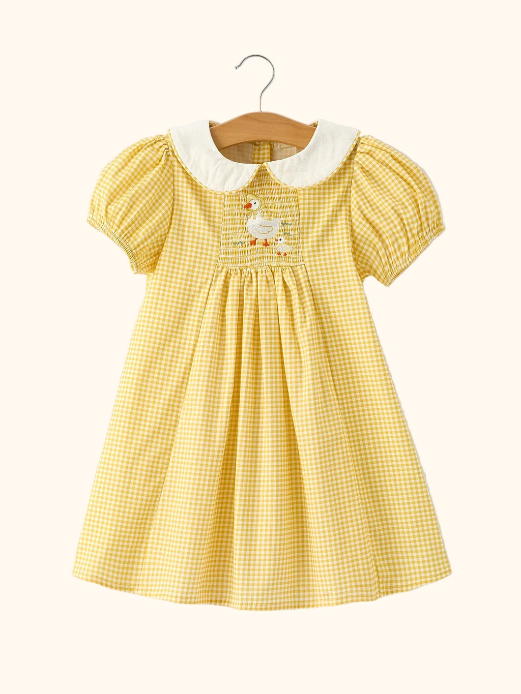 Yellow kids gingham smocked goose dress with white Peter Pan collar and puff sleeves, front view