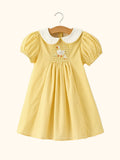 Yellow kids gingham smocked goose dress with white Peter Pan collar and puff sleeves, front view