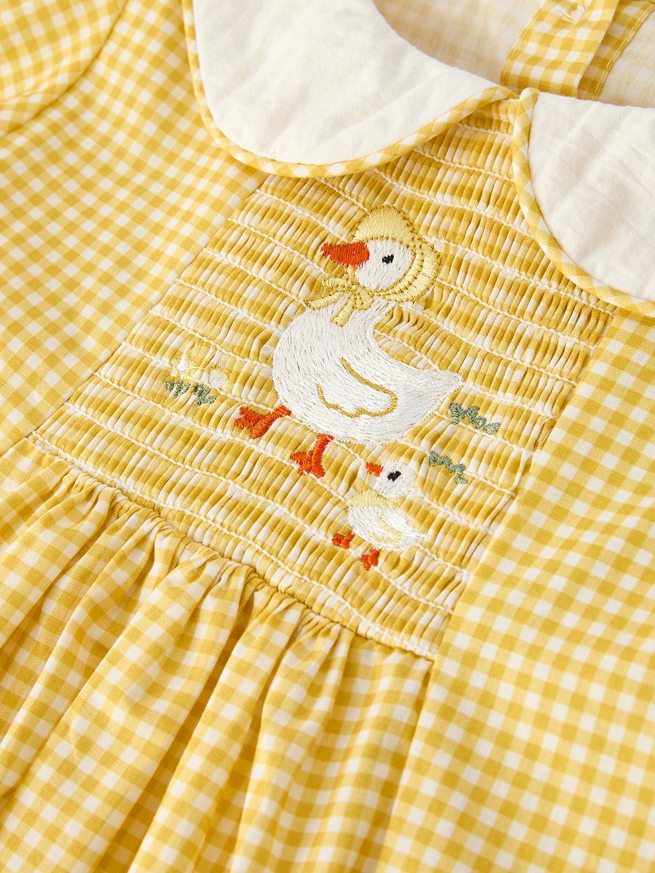 Yellow kids gingham dress with white Peter Pan collar and puff sleeve, neckline detail