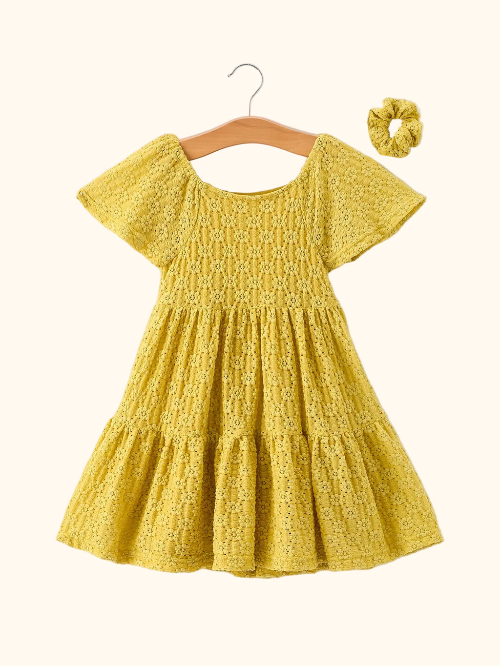 Yellow kids lace tiered dress with matching scrunchie and flutter sleeves, front hanging view