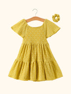 Yellow kids lace tiered dress with matching scrunchie and flutter sleeves, front hanging view