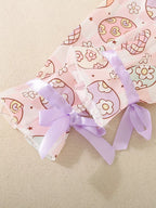 Pink kids egg print pajama sleeve with lavender bow and ruffled cuff, detail view