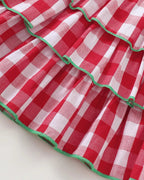 Red and white gingham tiered dress with green contrast trim, skirt detail view