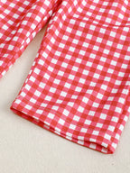Red and white gingham baby and toddler pants with finished leg hem, close-up view