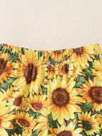Yellow sunflower print baby and toddler bell bottom pants with elastic waistband, close-up view