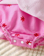 Hot pink baby floral romper with elastic leg openings and snap crotch, bottom detail view