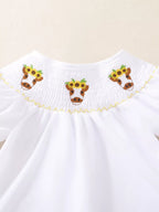 White baby and toddler smocked top with three cow and sunflower embroidery details, neckline close-up