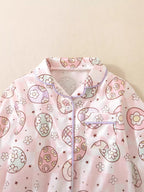 Pink kids egg print pajama top with collar, button front, and chest pocket, close-up view