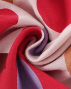 Pink kids floral print cotton blend fabric with red, lavender, and tan details, close-up view