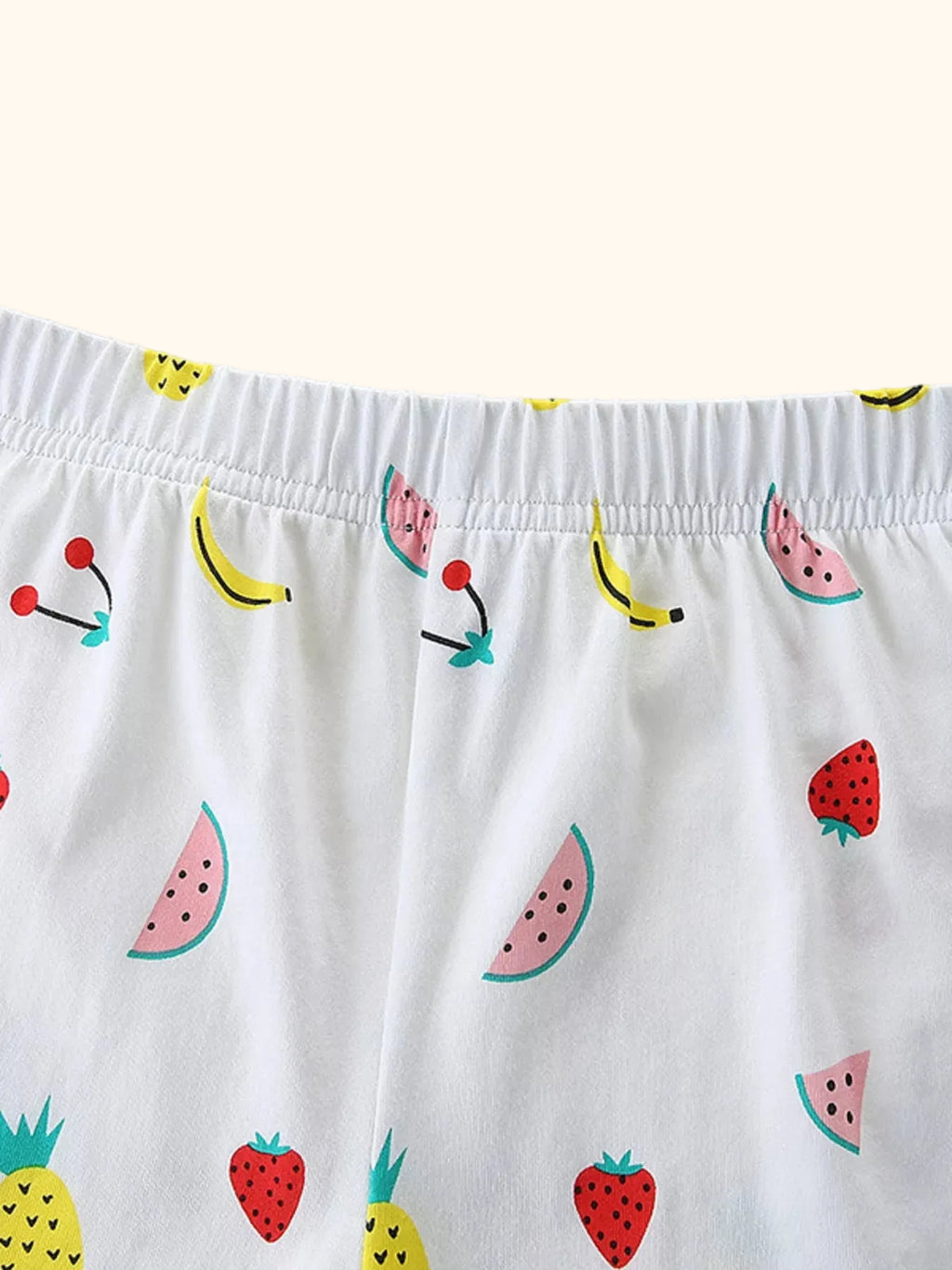 White kids fruit print shorts with pineapple, watermelon, strawberry, banana, and elastic waist, detail view