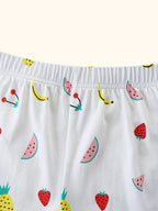 White kids fruit print shorts with pineapple, watermelon, strawberry, banana, and elastic waist, detail view