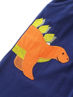 Dark navy kids pants with orange dinosaur appliqué and embroidered spikes, detail view
