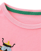 Blush pink kids long-sleeve dress with round neckline and green inner trim, neckline close-up