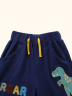 Navy kids shorts with dinosaur graphic, ROAR-SOME lettering, pockets and yellow drawcord, front detail