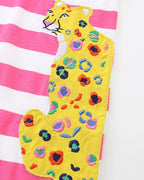 Pink striped kids dress with yellow leopard appliqué pocket and colorful embroidered spots, detail view